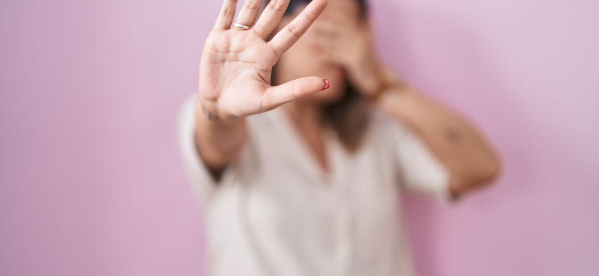 Blonde woman standing over pink background covering eyes with hands and doing stop gesture with sad and fear expression. embarrassed and negative concept.
