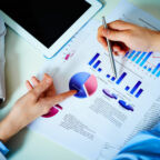Close-up of female and male hands pointing at business document while discussing it